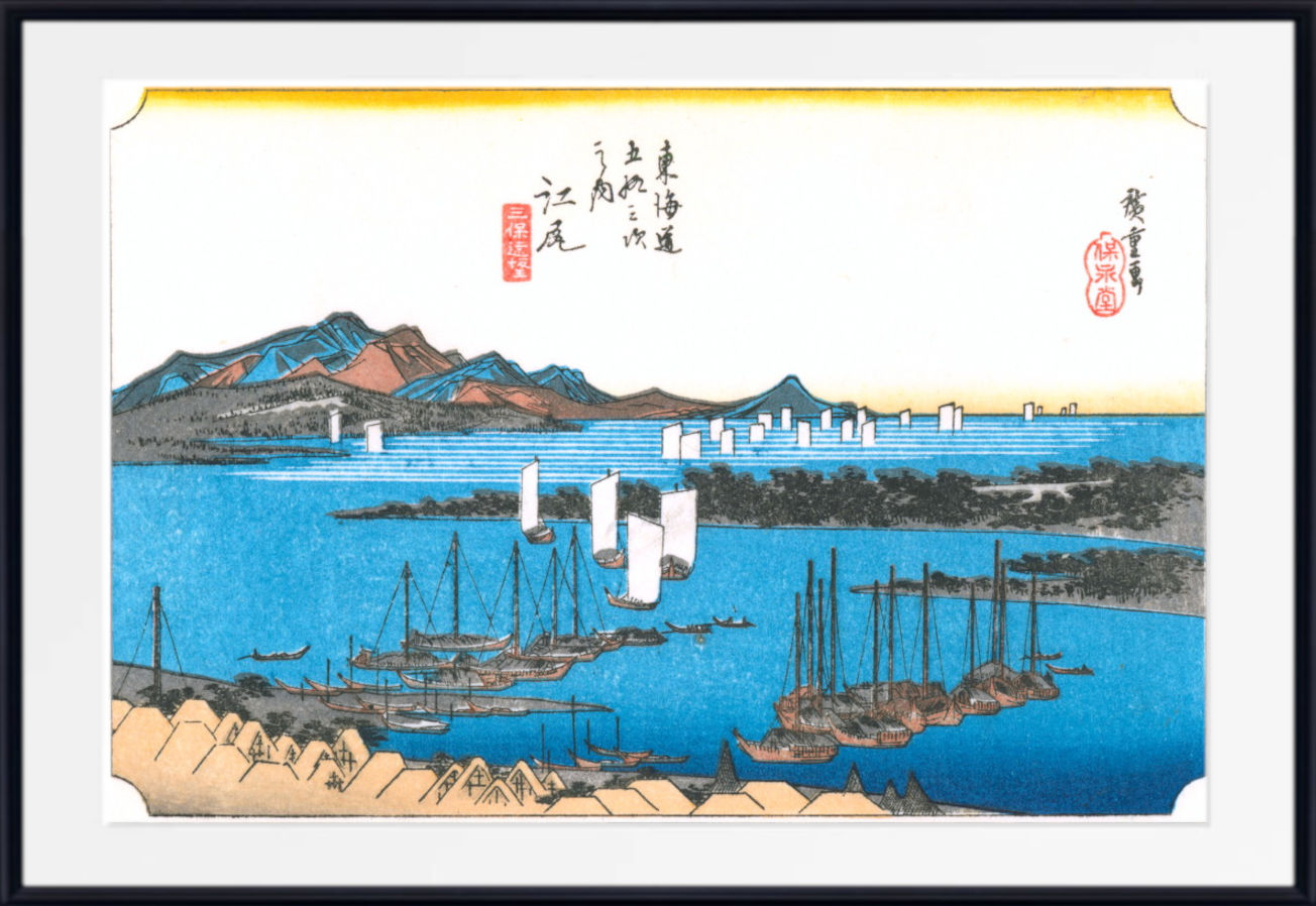 A framed Japanese-style harbor artwork showing blue water, sailboats, mountains, and buildings, with a white mat and black frame.