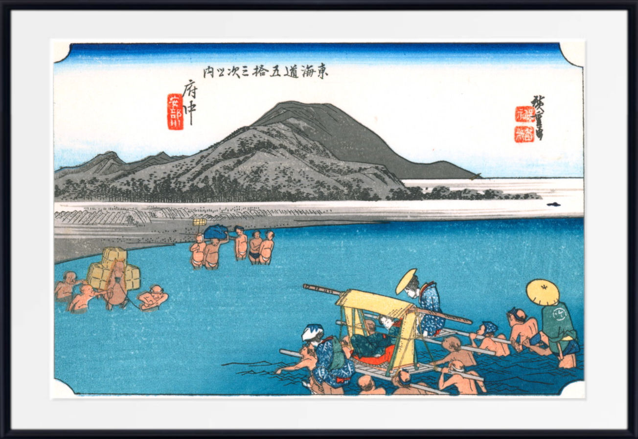 A framed Japanese ukiyo-e style print showing several figures swimming and bathing in bright blue water, with a large dark mountain in the background and red seal marks near the top.