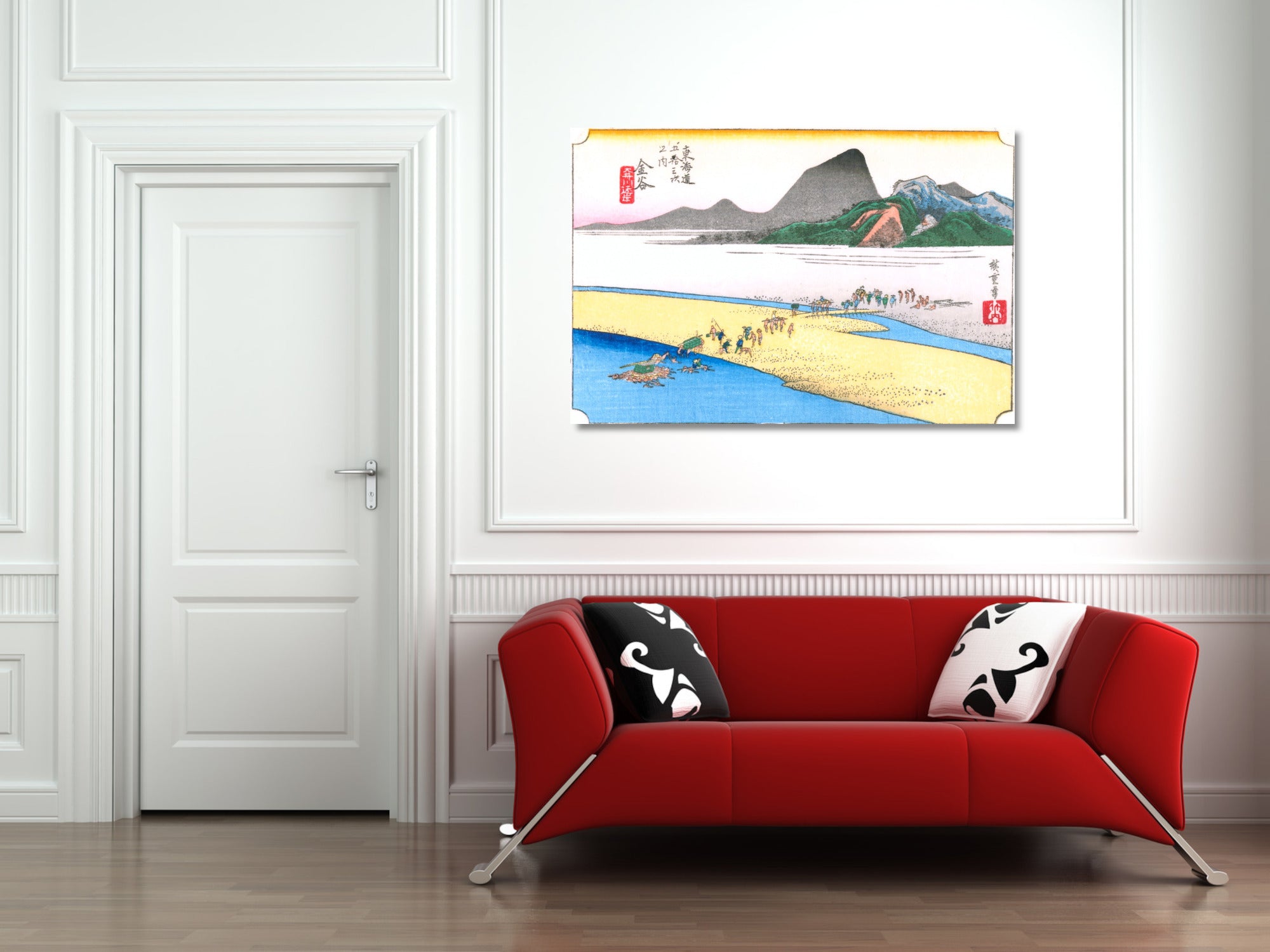A framed Japanese-style landscape art print hangs on a white wall above a modern red sofa with black-and-white patterned pillows in a bright room.
