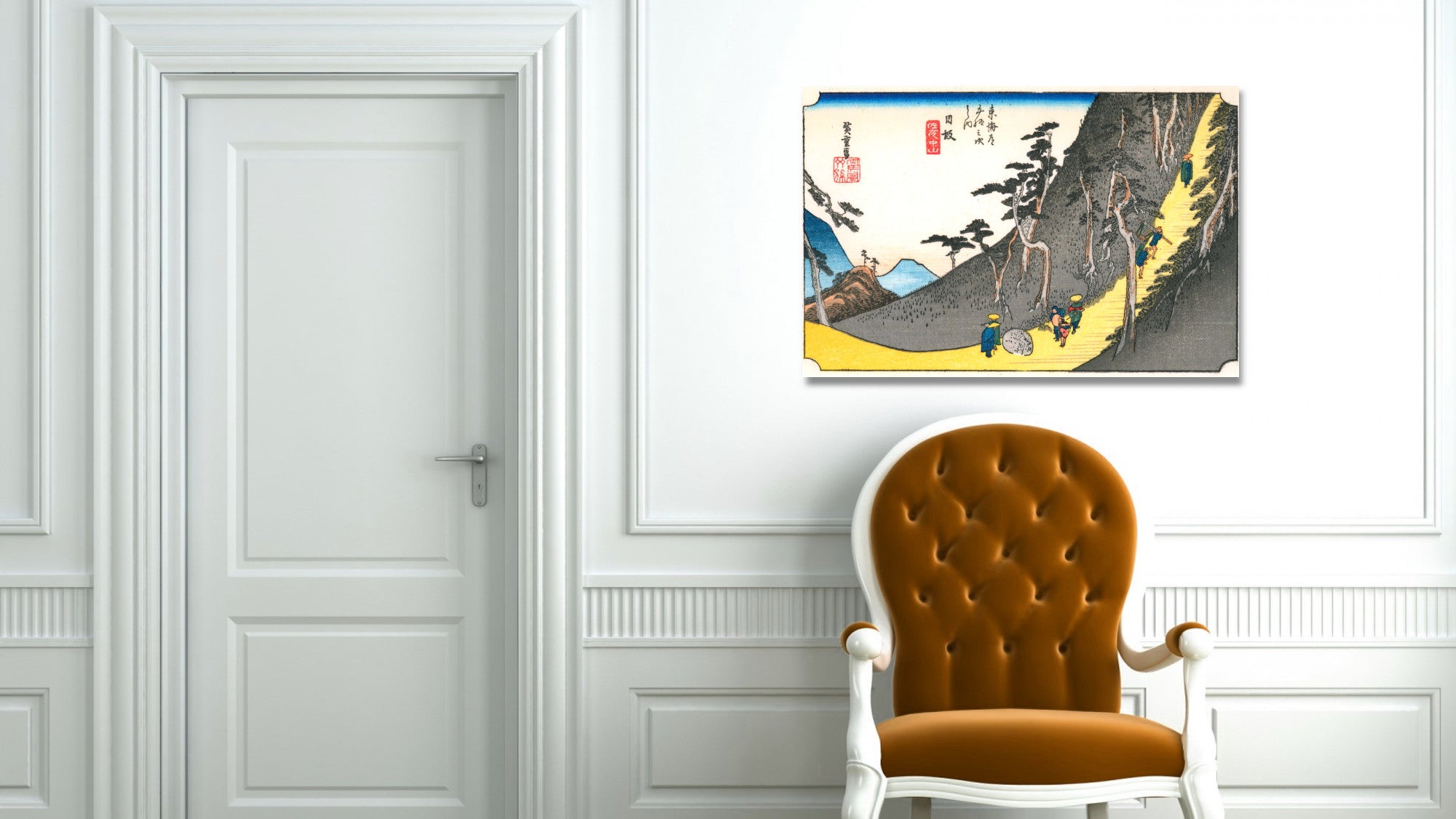 A framed Japanese-style art print depicting a mountain landscape hangs on a white paneled wall above an orange-brown tufted armchair next to a white door.