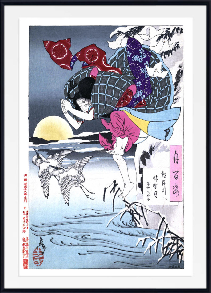 A framed Japanese ukiyo-e woodblock print featuring a woman in a patterned kimono carrying a large bundle across a snowy landscape at sunset, with cranes and reeds in the foreground. The print is shown with a white mat and black frame.
