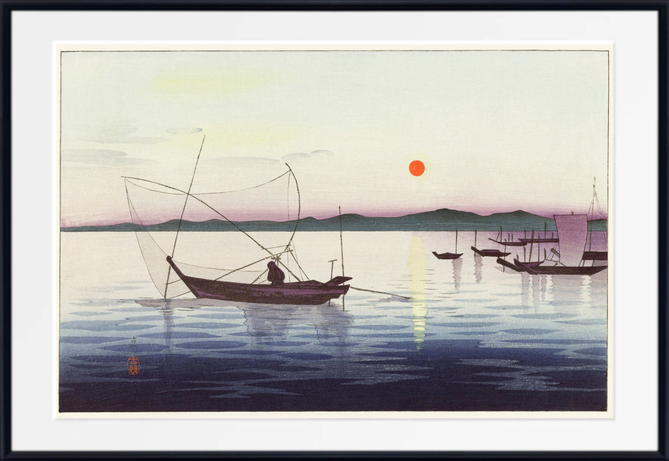 A framed art print depicting a serene Japanese-style harbor scene at sunset, with several boats on calm water, a small orange sun, and distant mountains. The print is matted with a white border and enclosed in a black frame.