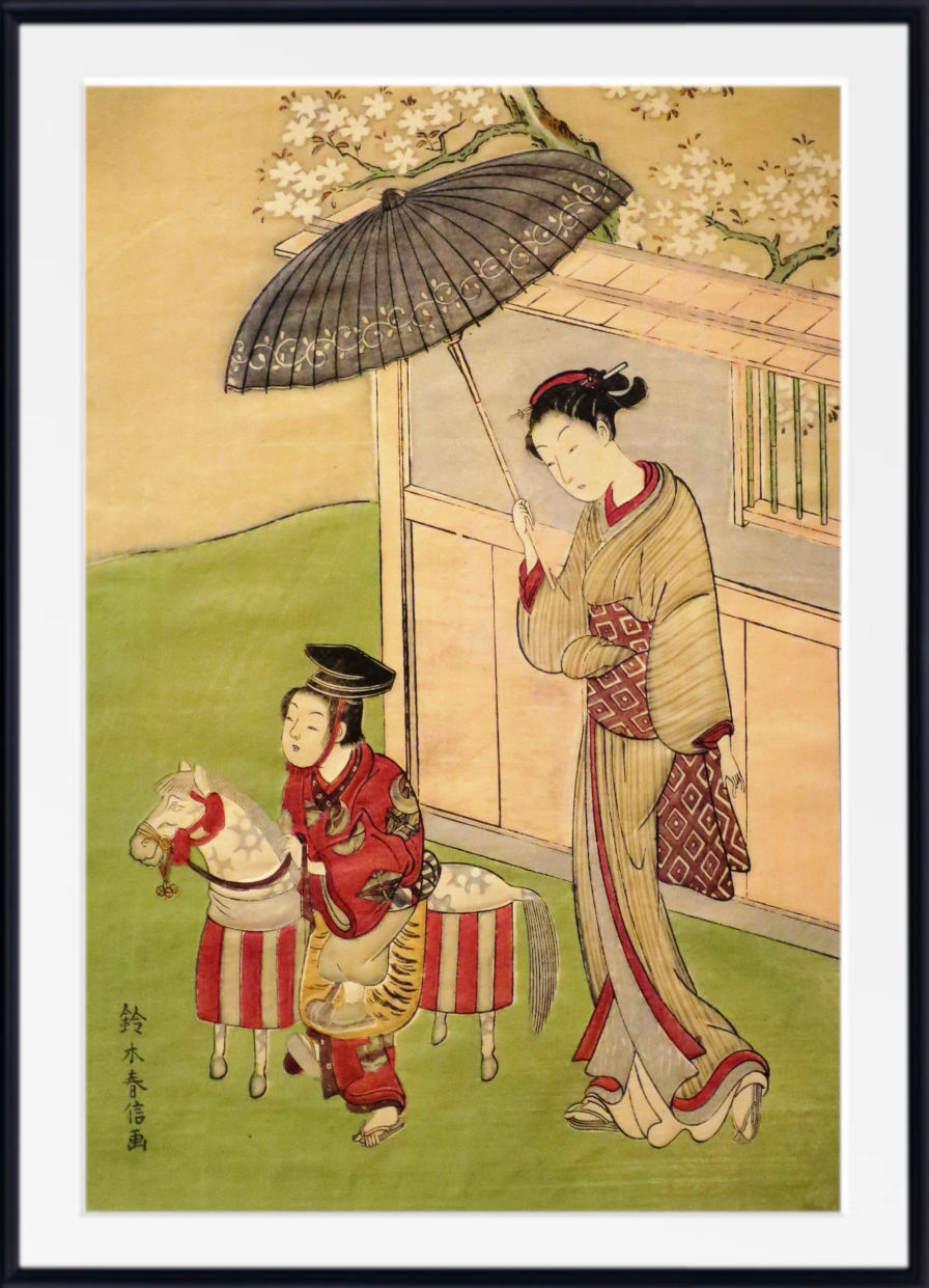 A framed Japanese-style art print depicting a woman in a beige kimono with red patterns holding a dark parasol, standing beside a child in a red outfit near a small horse, with cherry blossoms and a building in the background.