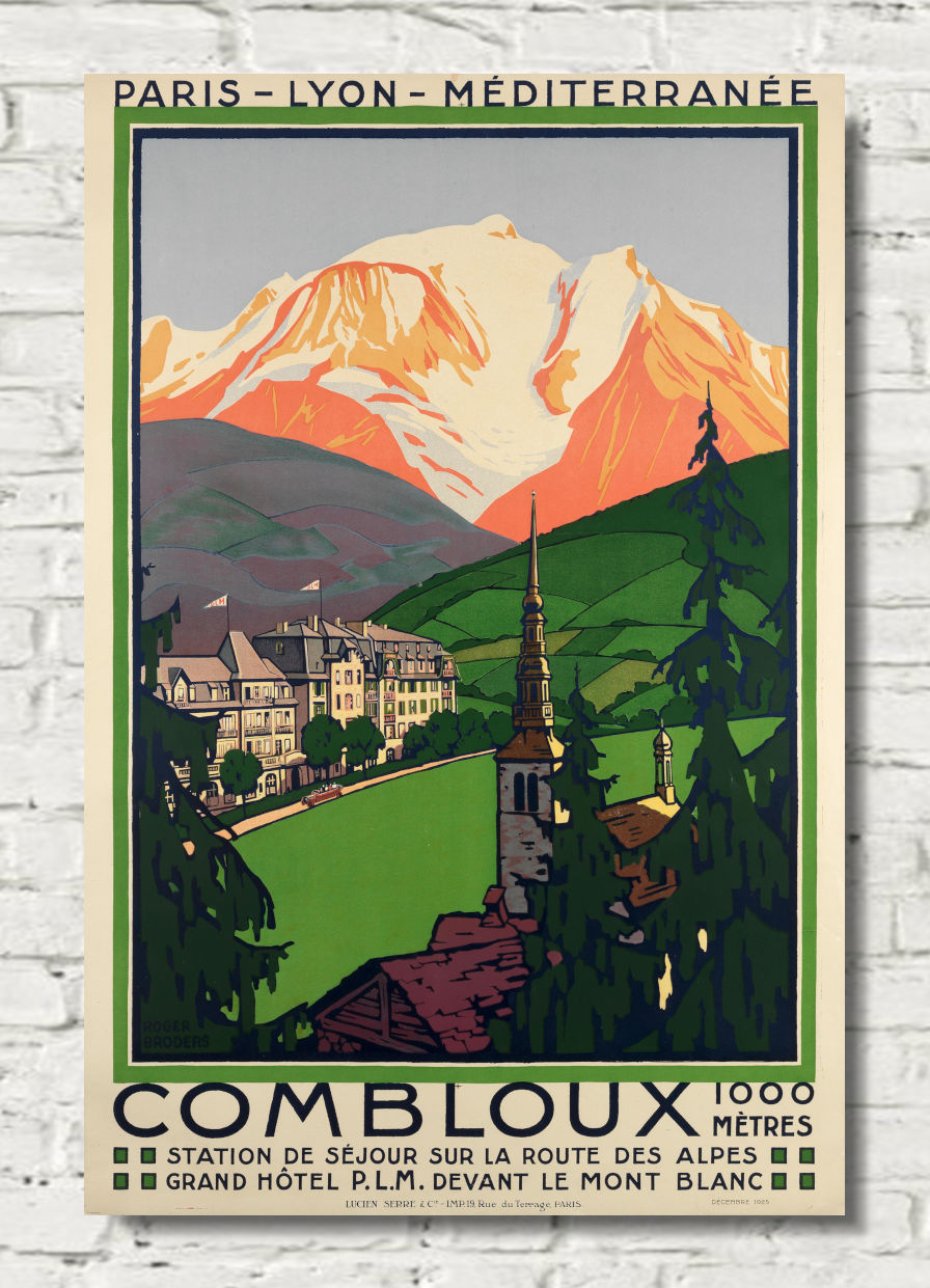 A vintage-style travel poster for Combloux, featuring a mountain landscape with snow-capped peaks, green hills, and a small town with a church spire, displayed against a white brick wall.