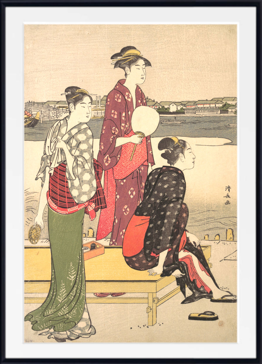 A framed Japanese ukiyo-e woodblock print depicting three women in traditional kimonos near a waterfront, with a light beige background and a black frame with white matting.