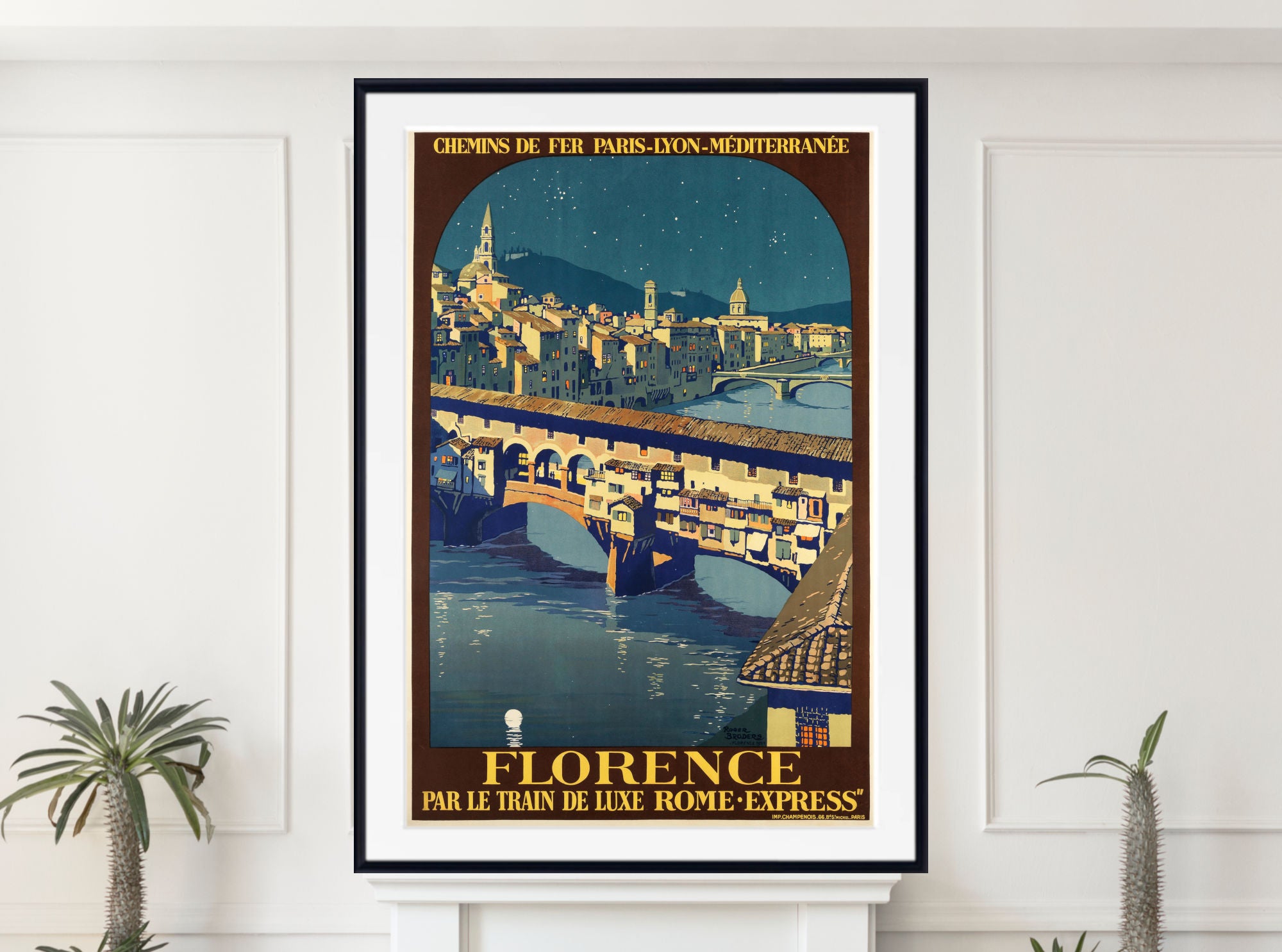 A framed vintage-style travel poster of Florence, Italy, hanging on a white wall above a white mantel with small potted plants at the bottom. The poster features an illustration of a bridge over a river with a city skyline under a night sky, with French text at the top and 'FLORENCE' at the bottom.