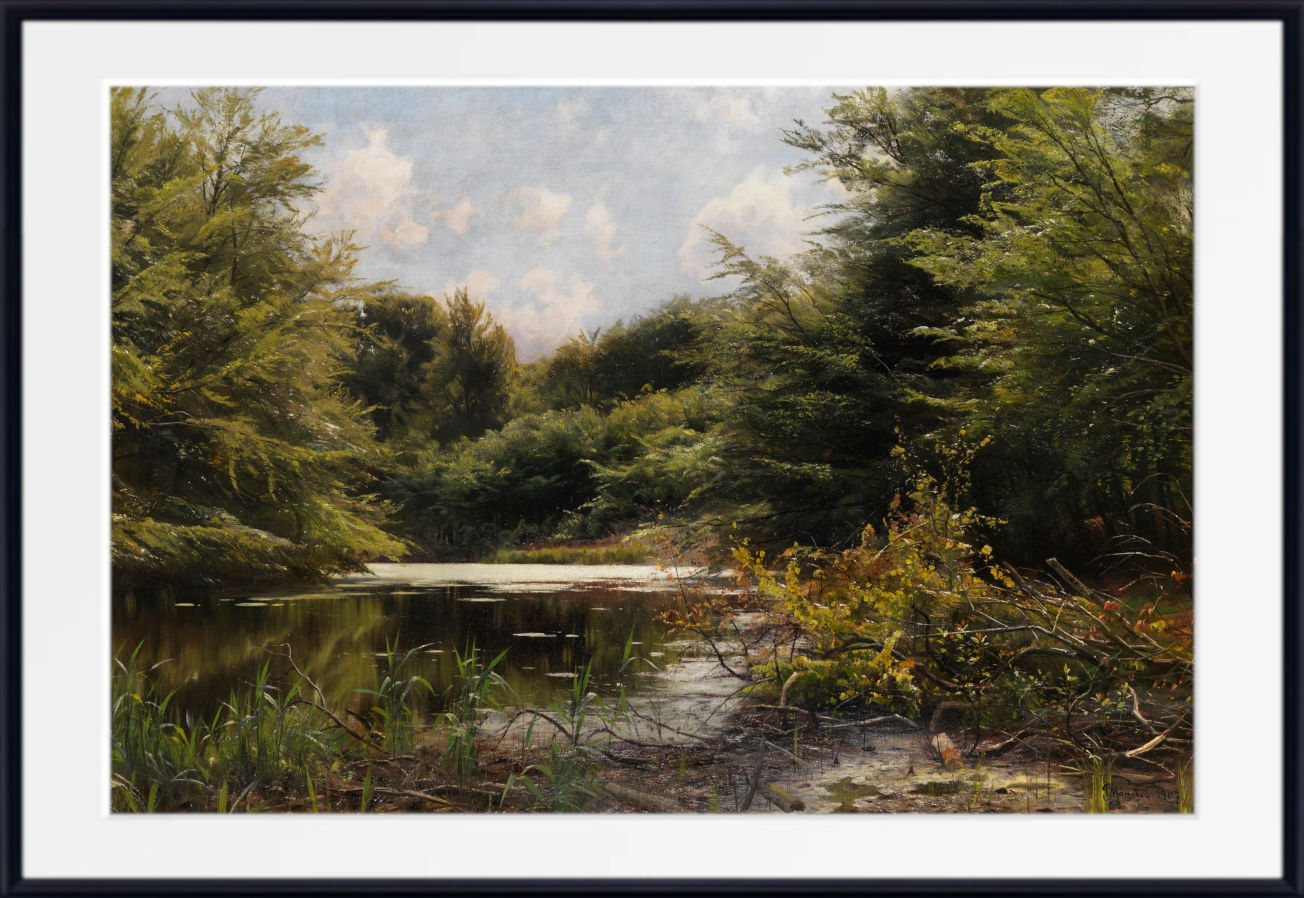 A framed landscape painting depicting a serene pond surrounded by lush green trees and reeds under a cloudy sky, presented with a white mat and black frame.