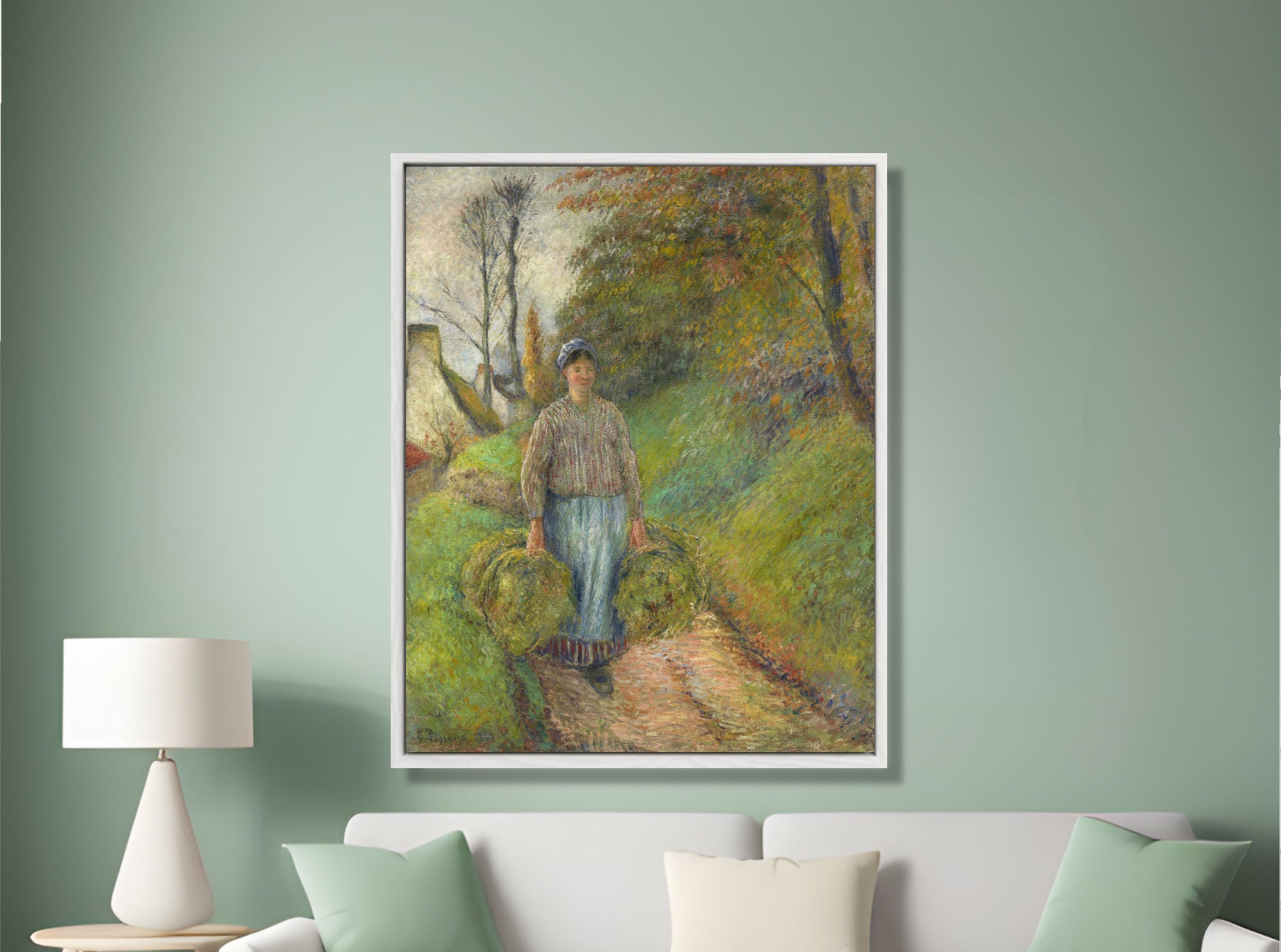 Framed painting of a woman walking in a park on a green wall above a sofa.