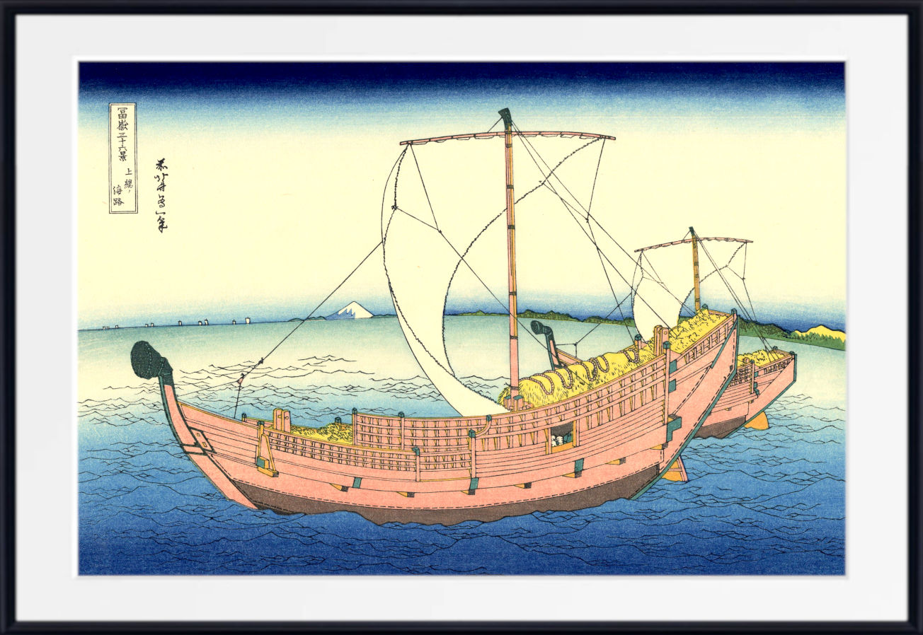 A framed Japanese-style art print showing two wooden sailing ships on blue water under a pale sky, with a white mat and black frame around the artwork.