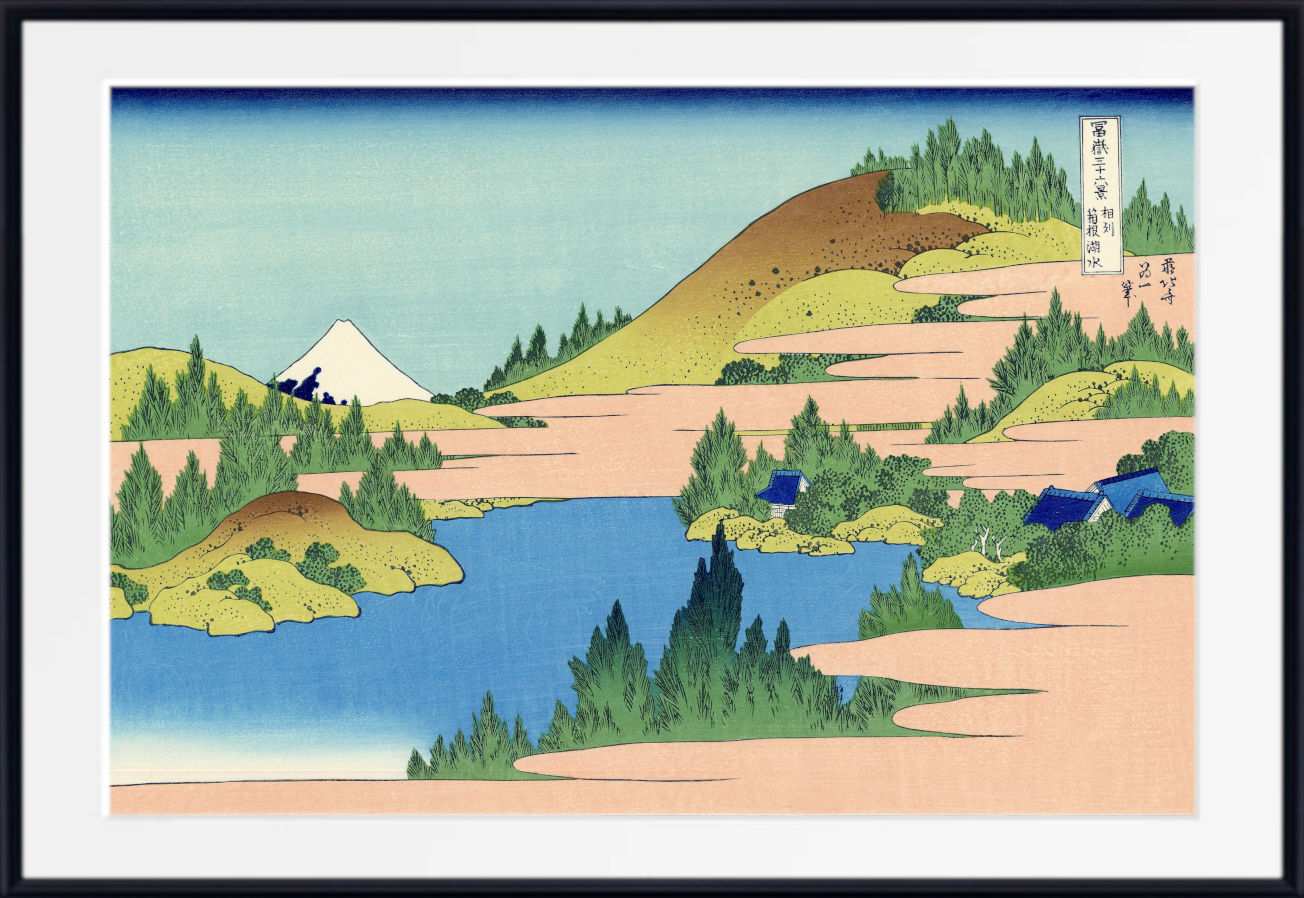 A framed Japanese-style landscape print showing blue water, sandy banks, green trees, and a white mountain under a pale blue sky, with a black frame and white mat.