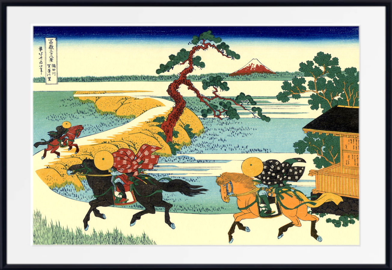 A framed Japanese ukiyo-e woodblock print showing riders on horseback traveling along a riverbank, with a tree, house, and distant mountain. The artwork is presented with a wide white mat and a black frame.