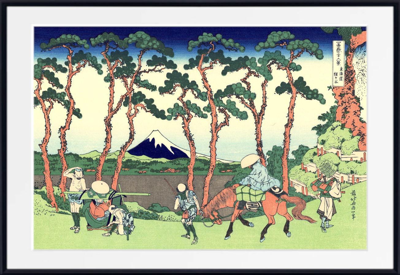 A framed Japanese ukiyo-e woodblock print depicting Mount Fuji, tall pine trees, and several figures on horseback and on foot in a landscape scene.