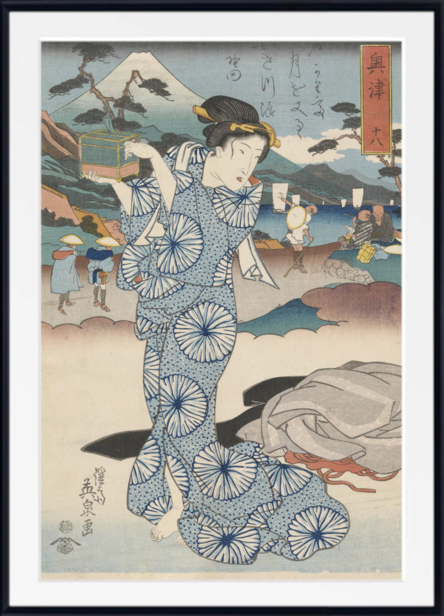 A framed Japanese ukiyo-e woodblock print featuring a woman in a blue patterned kimono standing in front of a coastal landscape with Mount Fuji, figures, boats, and buildings. The print is shown with a white mat and black frame.