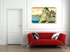 A framed Japanese ukiyo-e style art print depicting a green mountain landscape with blue water, displayed on a white wall above a modern red sofa with black and white patterned pillows.