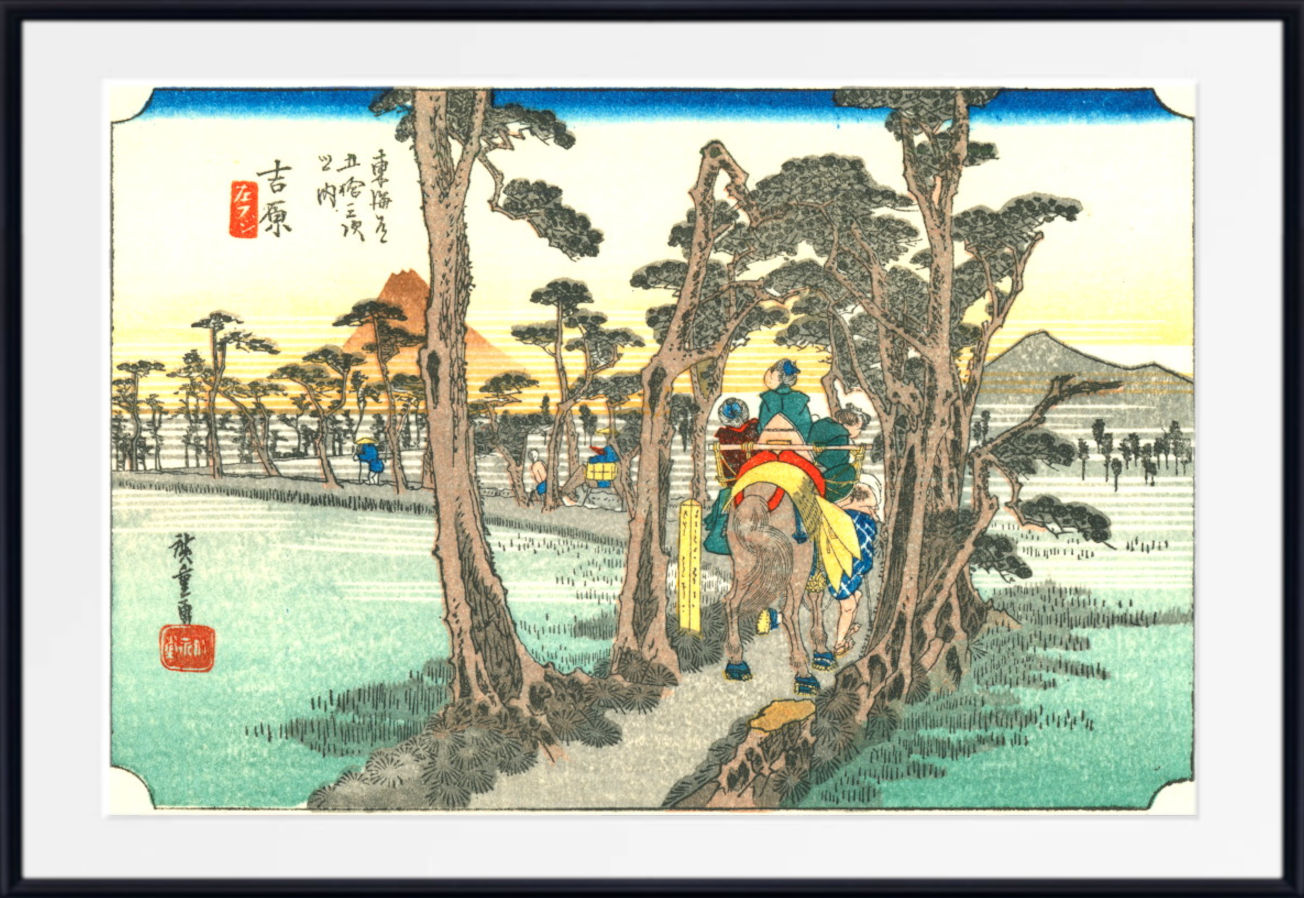 A framed Japanese-style art print depicting a rider on horseback traveling through a forest path, with trees, fields, mountains, and Japanese text visible on the artwork. The print is shown with a white mat and a black frame against a light gray background.