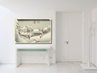 A framed Japanese-style winter landscape art print hangs on a white wall above a white console table in a bright, modern minimalist room.