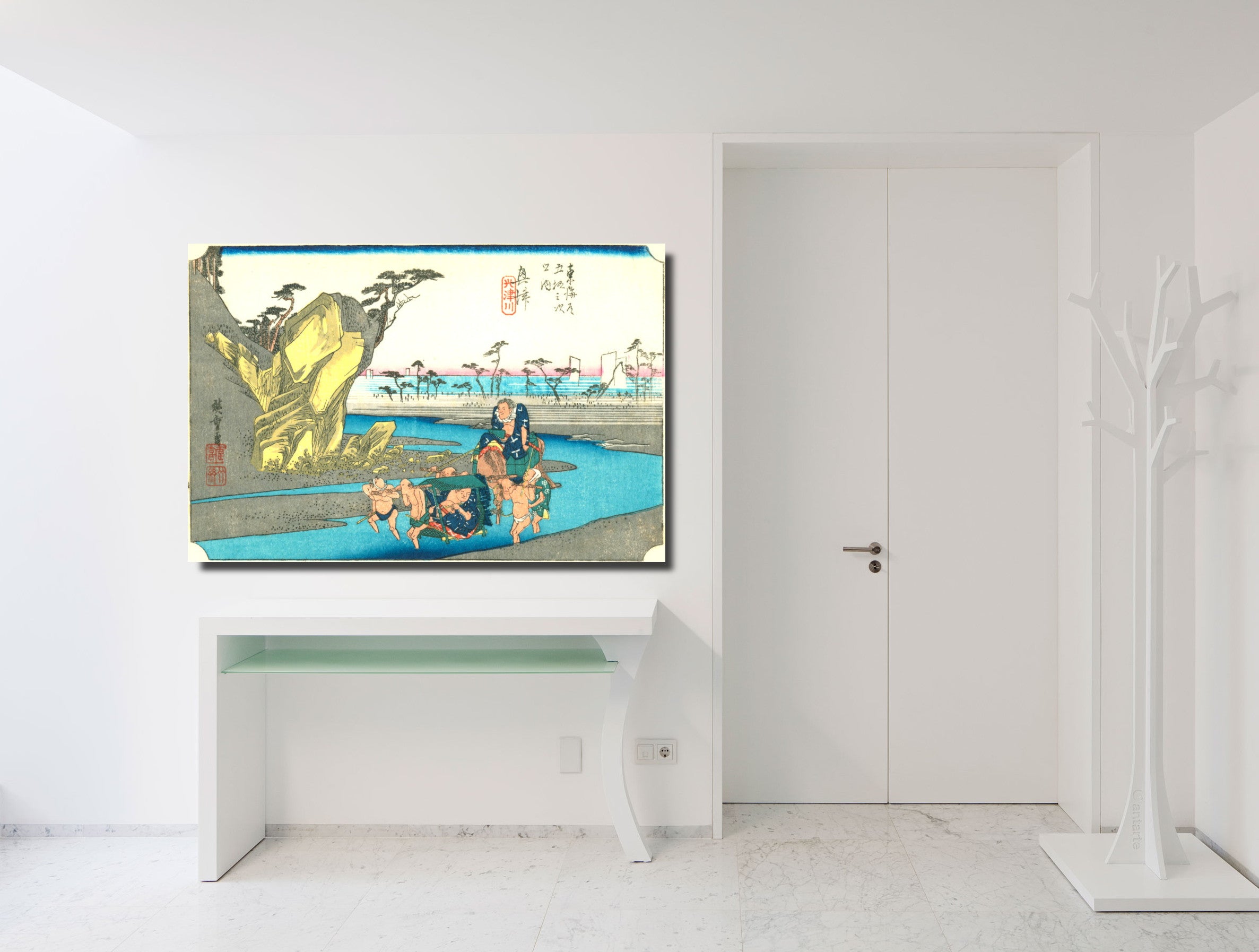A framed Japanese ukiyo-e woodblock print depicting a woman by a pool, displayed on a white console table in a minimalist white room.