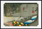 A framed Japanese-style art print showing a rainy outdoor scene with trees, a river or waterfall in blue tones, and small figures in red and yellow clothing. The print is presented with a white mat and black frame.