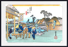 A framed Japanese ukiyo-e woodblock print depicting a village scene with figures, a horse, boats, and traditional buildings, shown against a white mat and black frame.