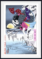 A framed Japanese ukiyo-e woodblock print featuring a woman in a patterned kimono carrying a large bundle across a snowy landscape at sunset, with cranes and reeds in the foreground. The print is shown with a white mat and black frame.
