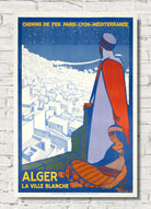 A vintage-style travel poster for Alger, featuring an Art Deco illustration of a man in a red and white cloak overlooking a white cityscape under a dark blue sky. The text reads 'CHEMINS DE FER PARIS-LYON-MÉDITERRANÉE' at the top and 'ALGER LA VILLE BLANCHE' at the bottom.