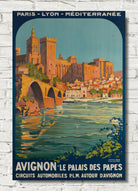 A vintage-style travel poster for Avignon, France, featuring the Palais des Papes and a stone bridge over blue-green water, displayed against a white brick wall background.