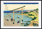 A framed Japanese ukiyo-e woodblock print depicting figures near torii gates by the water, with pale blue water, green trees, and a cream sky, shown in a black frame with a white mat.