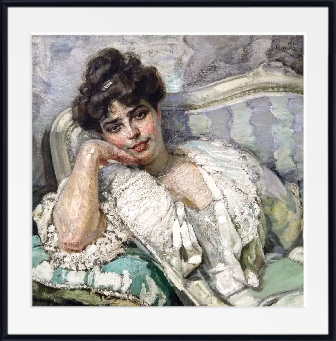 A framed painting of a woman reclining on a patterned sofa, rendered in soft pastel or impasto brushwork with muted green, cream, gray, and pink tones. The artwork is shown with a white mat and black frame against a light neutral background.
