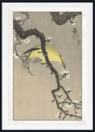 A framed Japanese-style art print featuring a yellow bird perched on a dark flowering branch against a textured beige background, with a white mat and black frame.