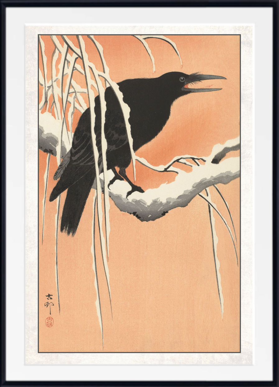 A framed Japanese-style art print depicting a black bird perched on a snowy branch against a warm peach background, with a white mat and black frame.