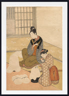 A framed Japanese-style art print depicting two women in traditional kimonos seated indoors, with one standing woman holding a child and another woman kneeling beside them. The print is shown with a white mat and a black frame against a light neutral background.