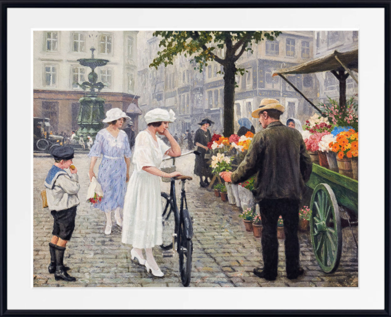 A framed art print depicting a vintage street scene with people, a woman in a white dress on a bicycle, and a flower cart, shown with a white mat and black frame.
