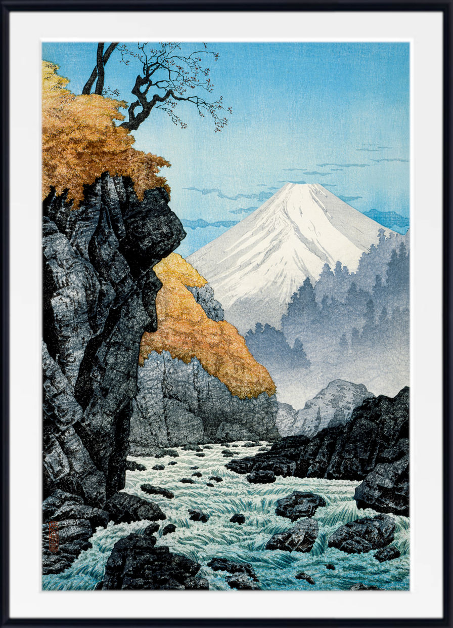 A framed art print depicting a Japanese-style landscape with a snow-capped mountain, rocky cliffs, autumn foliage, and a rushing river, shown against a white background with a black frame.