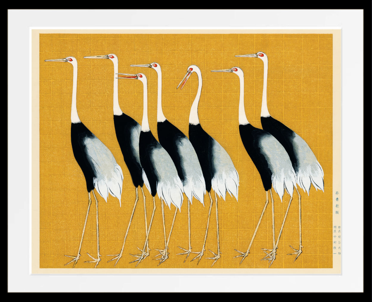 A framed art print depicting a row of five cranes with black and white bodies, white necks, and long legs, set against a mustard yellow background with a white mat and black frame.
