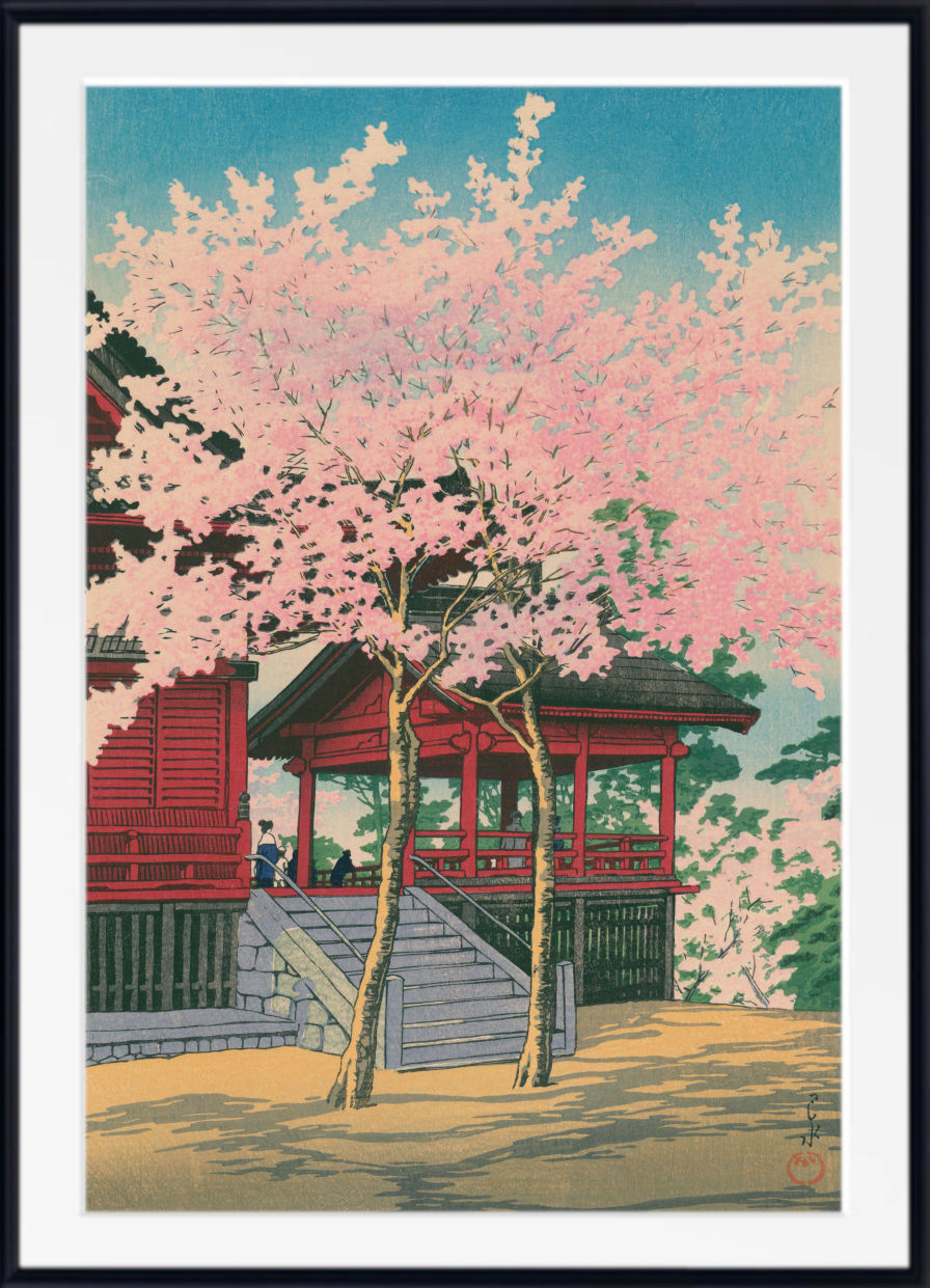 A framed Japanese-style art print depicting a red temple pavilion beneath a large pink cherry blossom tree, with a blue sky and green foliage in the background.