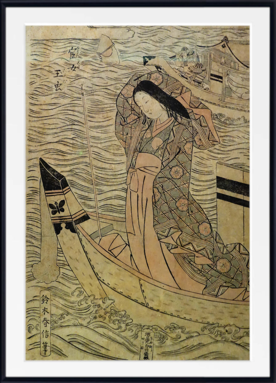 A framed Japanese woodblock-style art print showing a woman in a boat on stylized waves, with buildings and birds in the background. The print has an aged beige paper tone with black linework and muted tan and gray patterning, presented in a white mat and black frame.