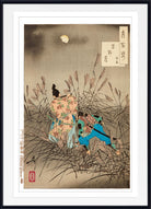 A framed Japanese ukiyo-e woodblock print depicting two figures in flowing garments among tall grass under a full moon, shown with a white mat and black frame.