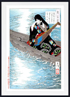 A framed Japanese ukiyo-e woodblock print depicting a woman in a black patterned kimono rowing in a boat on blue water, with Japanese text elements, shown in a black frame with a white mat.