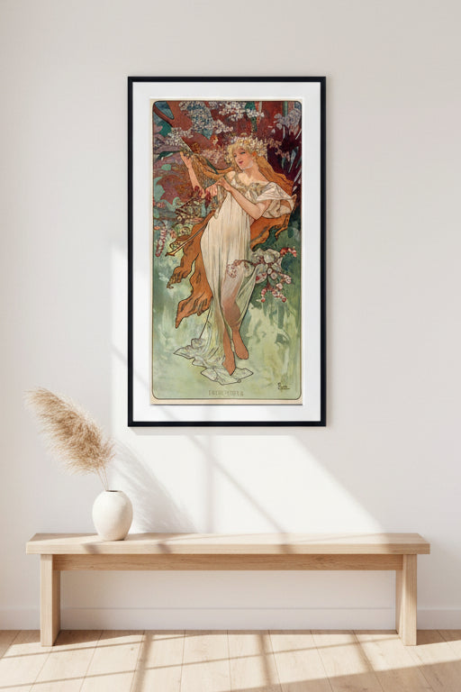 A framed Art Nouveau style print featuring a woman in a flowing white dress among flowering branches and foliage, with a black frame and white mat around the artwork.