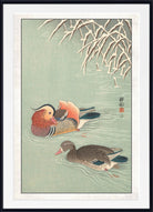 A framed Japanese-style art print depicting two ducks swimming in pale green water with reeds at the top and a white mat border.