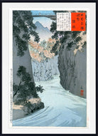 A framed Japanese woodblock-style landscape print showing a river flowing through a rocky canyon with trees and mountains in the background. The artwork includes a white border, black frame, and red text boxes with calligraphy.
