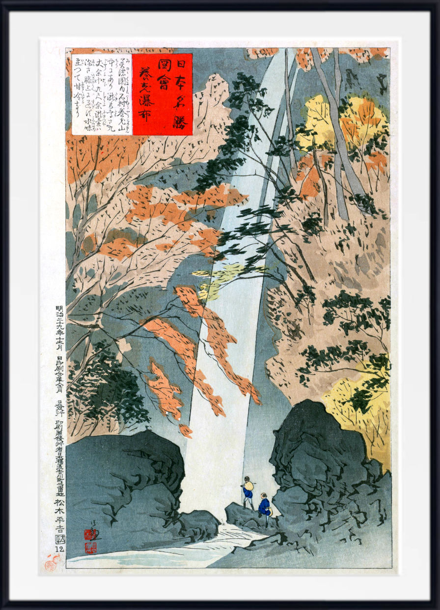 A framed Japanese ukiyo-e woodblock print depicting a waterfall flowing between rocky cliffs, with autumn-colored trees and two small figures near the base. The print is shown with a white mat and a black frame.