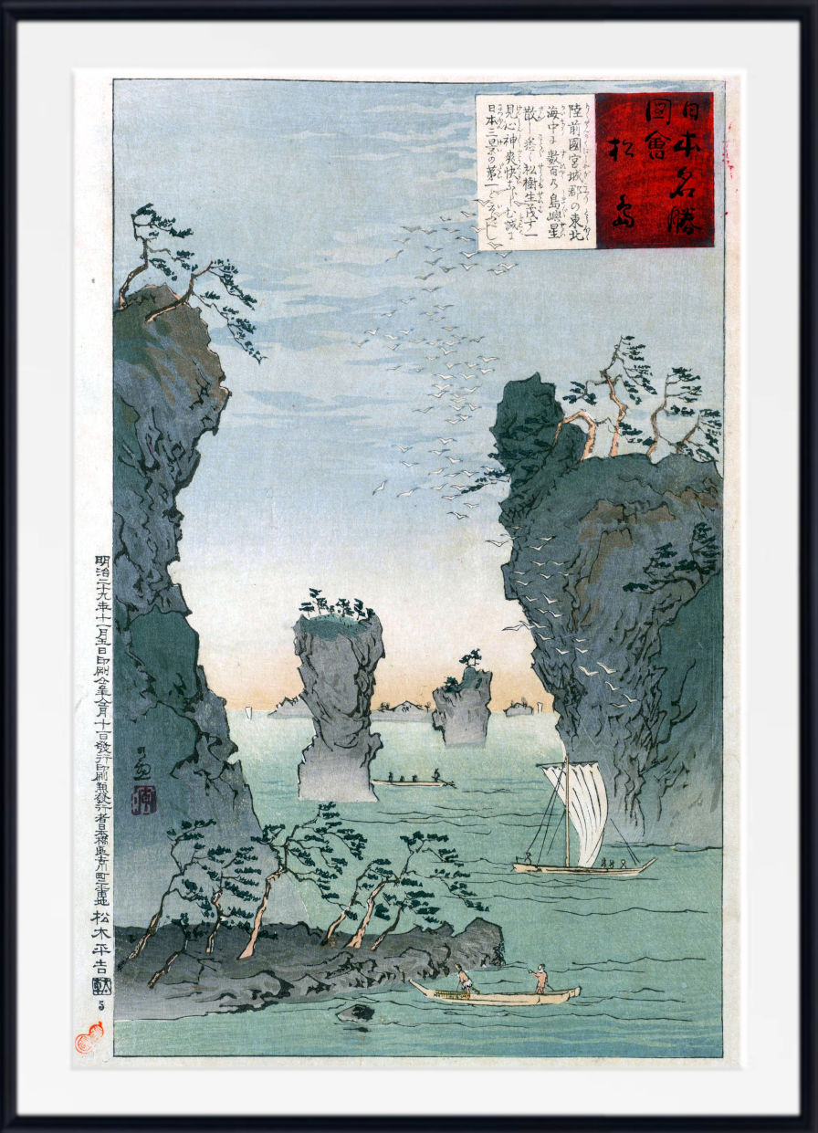 A framed Japanese ukiyo-e woodblock print depicting a coastal landscape with tall rocky cliffs, sea stacks, a small sailboat, and a canoe on calm water. The print has a white mat and a black frame, with a red and white seal block printed in the upper right corner.