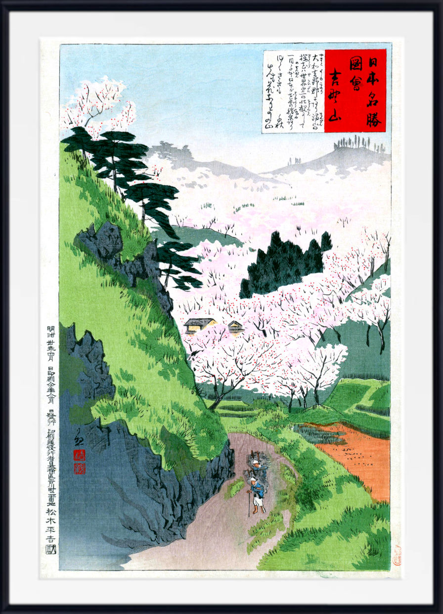 A framed Japanese ukiyo-e woodblock print depicting a mountain landscape with blooming cherry blossoms, green hills, a winding path, and a small figure, shown against a white background with a black frame.