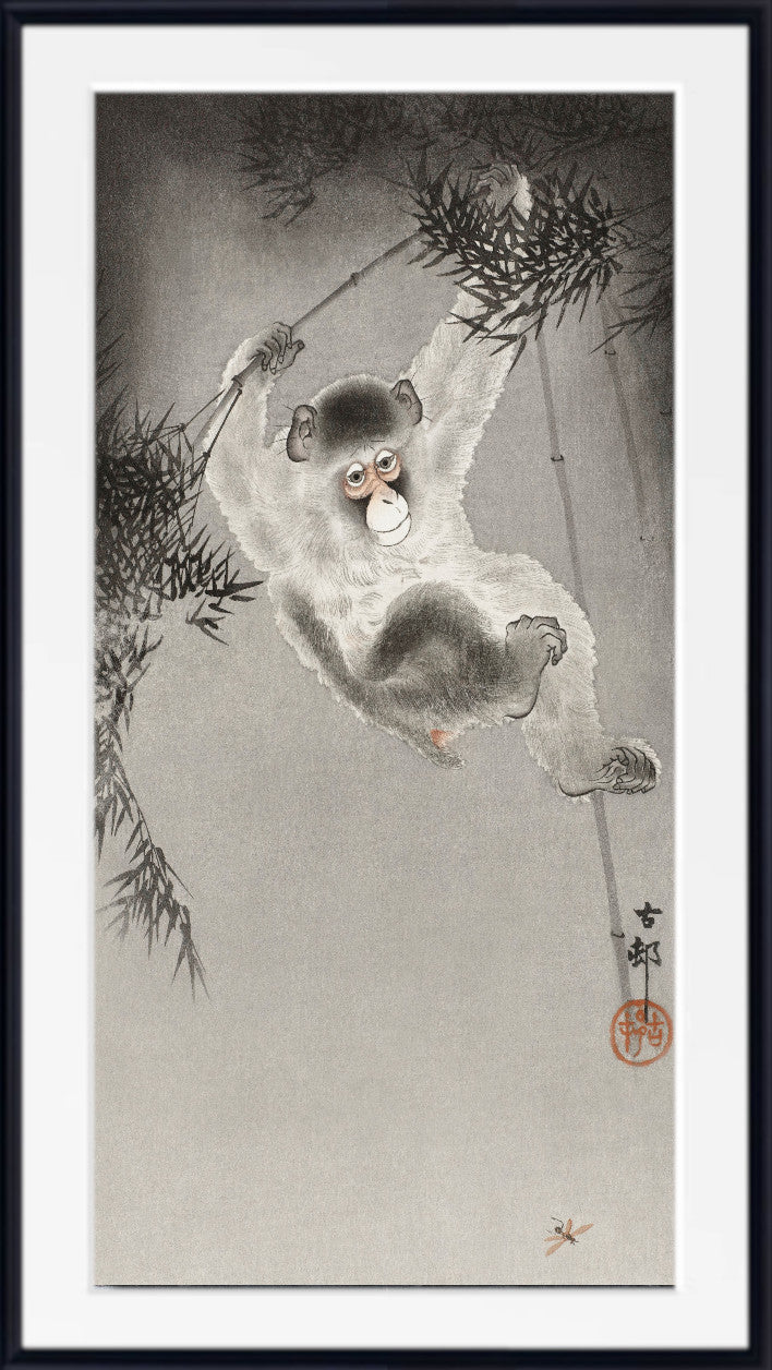 A framed Japanese-style art print depicting a monkey hanging from bamboo branches, with a light gray background and a black outer frame.