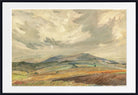 A framed landscape painting featuring rolling hills, distant mountains, and a dramatic cloudy sky, presented with a white mat and black frame.