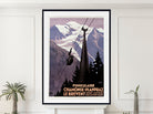 A framed vintage-style mountain cable car poster hangs on a white wall above a mantel, with small potted plants at the sides. The artwork shows snowy mountains, dark evergreen trees, and a cable car silhouette with French text at the bottom.