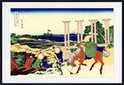 A framed Japanese woodblock-style art print showing figures near a river and large stone pillars, with a blue sky and pale ground. The print is centered within a white mat and a black frame.