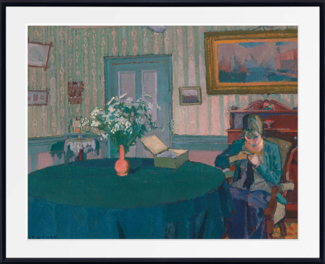A framed art print of an impressionist painting depicting a woman sewing in a room with striped wallpaper, a blue table, and a vase of white flowers.