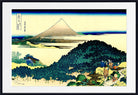 A framed Japanese-style art print depicting Mount Fuji with dark green trees, blue water, and small figures in the foreground, shown against a white mat and black frame.